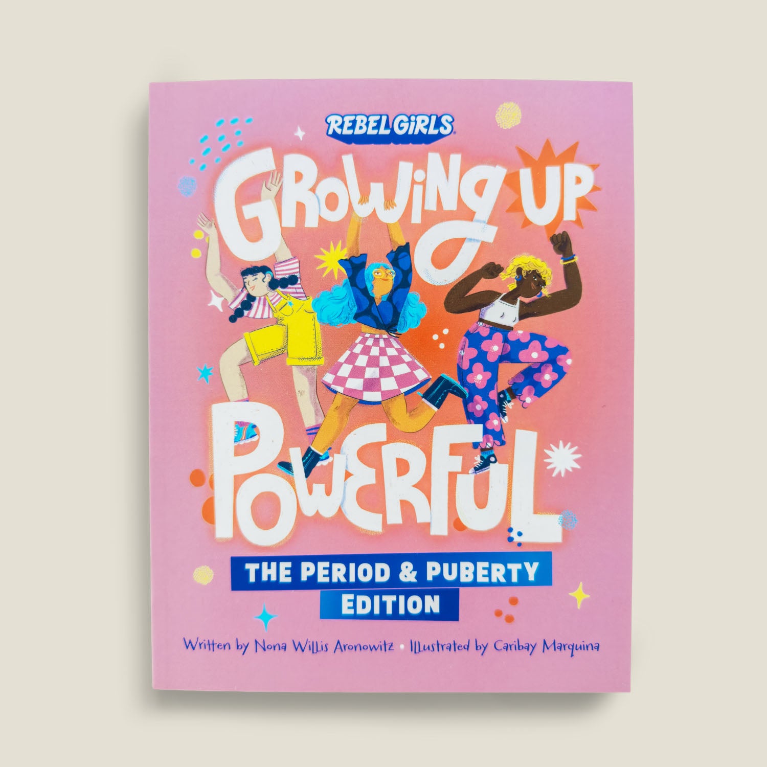 Front cover of "Growing Up Powerful: The Period & Puberty Edition" by Rebel Girls, featuring vibrant illustrations of diverse girls dancing on a pink background with bold title text.