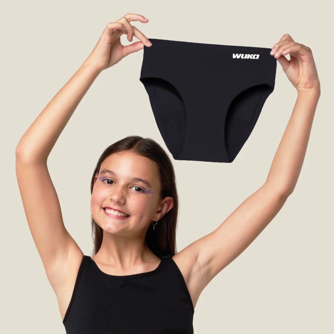 Teen holding WUKA Teen Stretch™ period pants, representing 5-star reviews praising reusable period underwear as better than pads and tampons