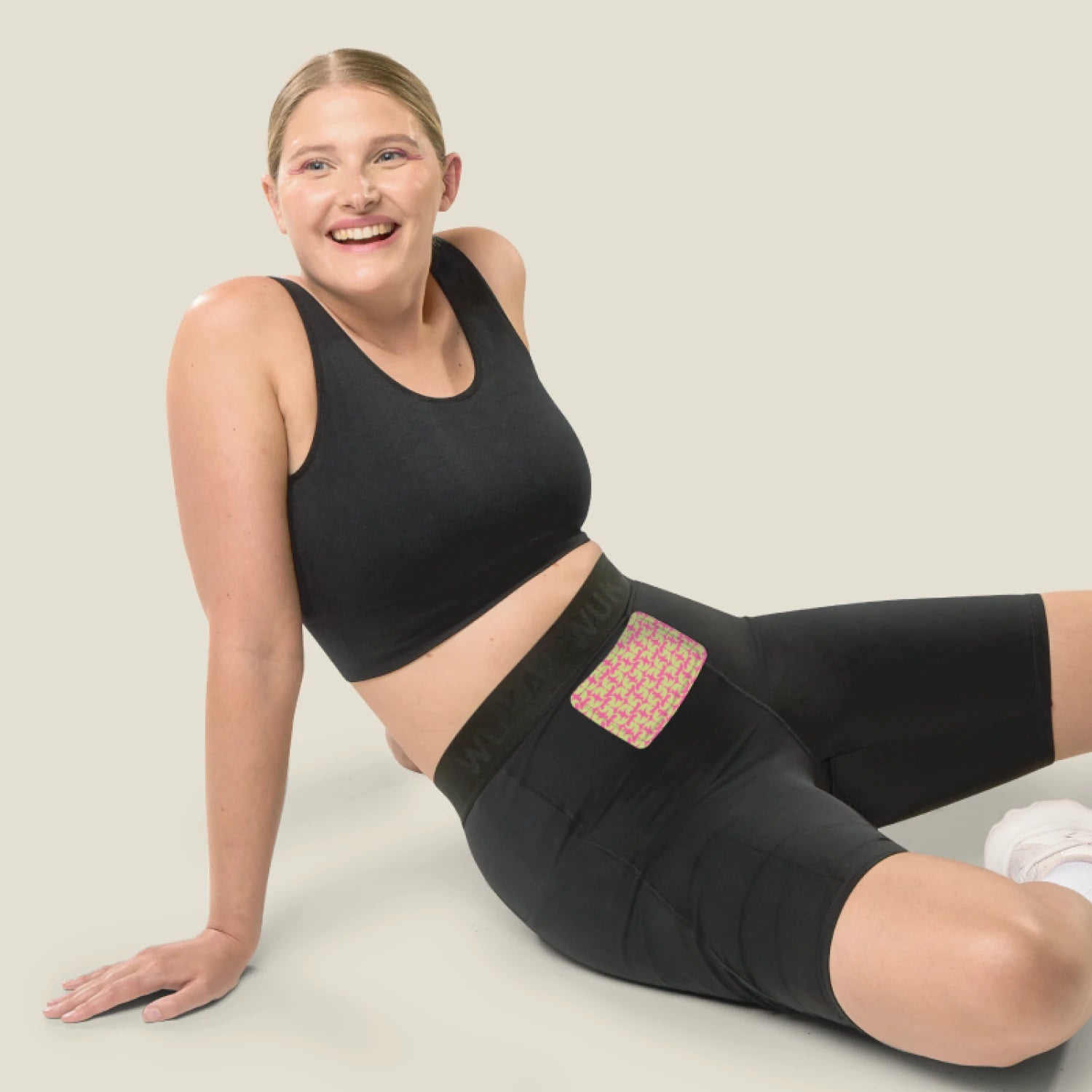 girl wearing heat patch on her leggings in a reclining position