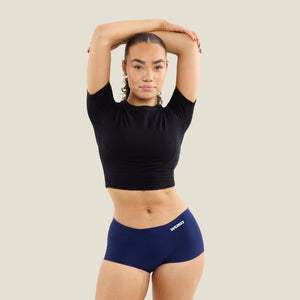 Teen model wearing WUKA Teen Stretch™ Boxer Short in navy, designed for heavy flow period protection, showing full-length front view.
