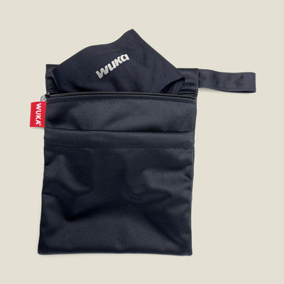 WUKA Two Pocket Changing Bag with black WUKA pants tucked inside the main zip pocket, showcasing compact and discreet storage for on-the-go period changes.