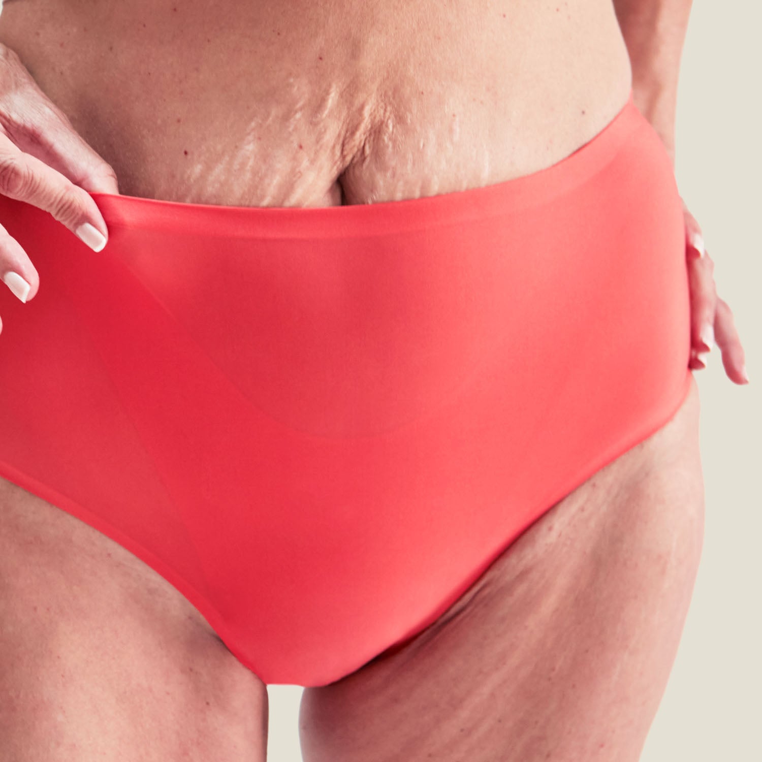 Detail shot of the Coral Pink Drytech™ Midi Brief being stretched, emphasizing the flexible, form-fitting waistband and breathable material.